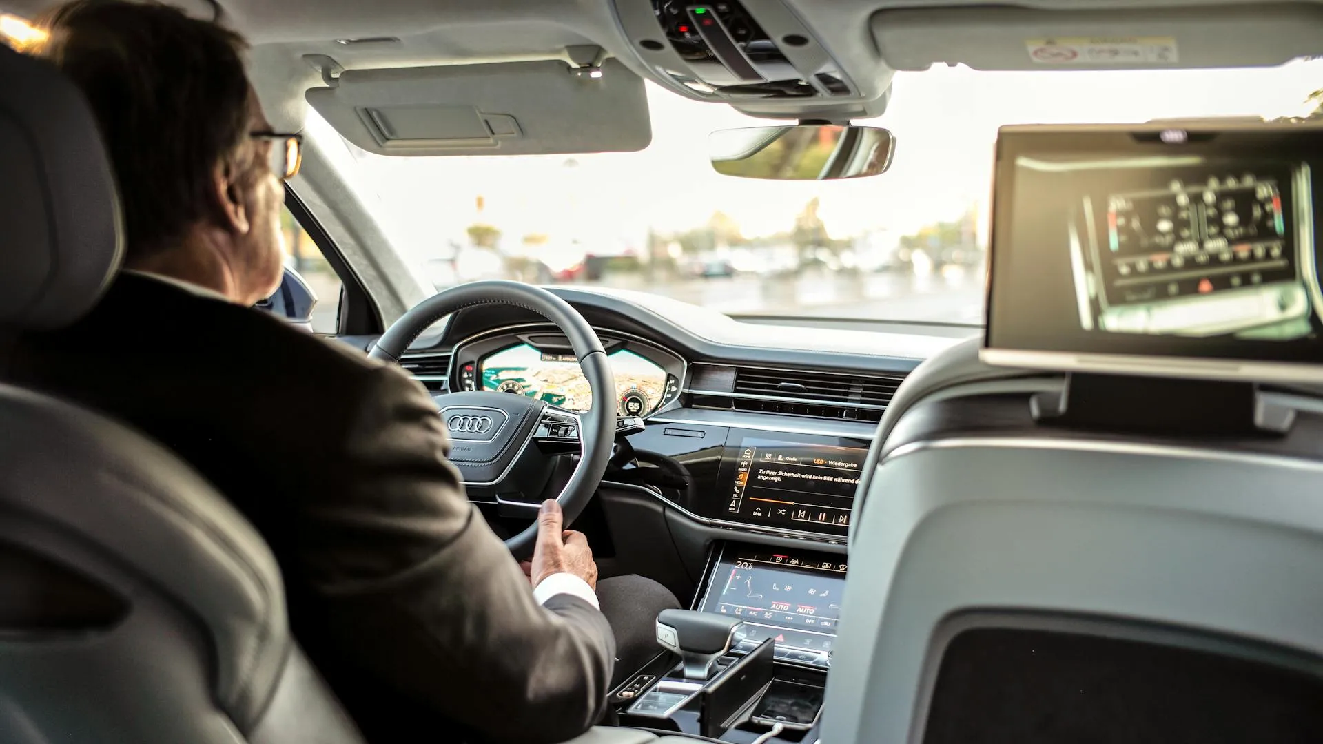 A driver at the wheel of a well-engineered car, mirroring the CEO's role in the AI Profit OS framework: you own the pain and the destination, the technical team owns the steps
